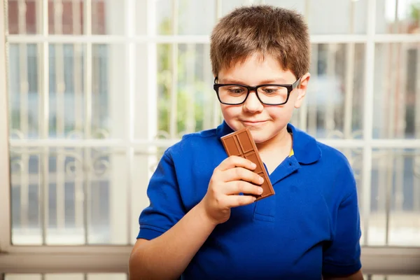 Ragazzo guardando la barretta di cioccolato — Foto Stock