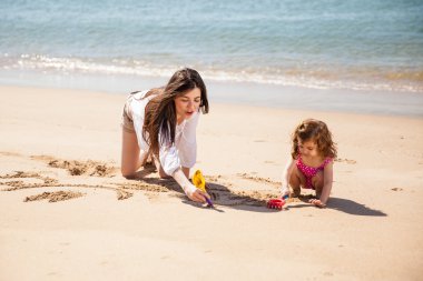 Küçük bir kızla oynayan bebek bakıcısı