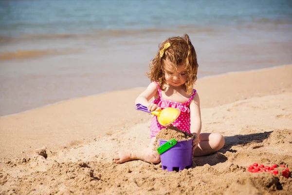 Девочка собирает песок — стоковое фото