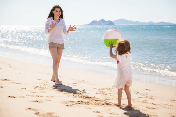 Schattig klein meisje gooien een strandbal — Stockfoto