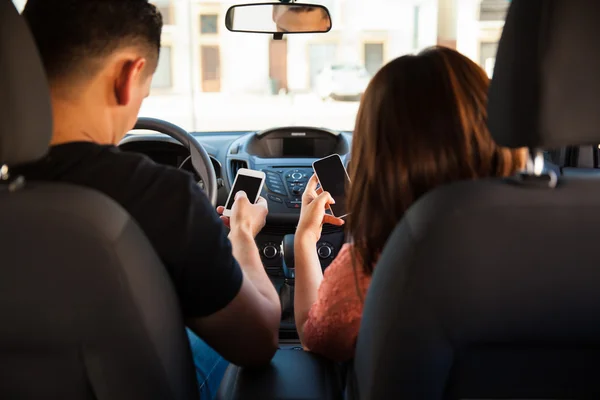 Paar schreibt SMS und fährt Auto — Stockfoto