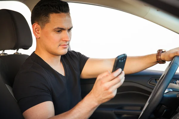 Homem olha para o seu smartphone — Fotografia de Stock