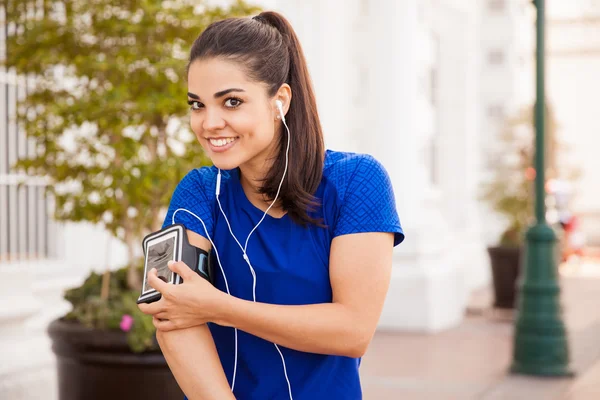 Brünette trägt Handy in Armbinde — Stockfoto