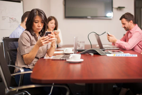 People in a conference room texting — 스톡 사진