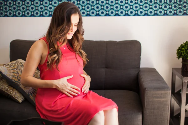 Mutter blickt auf ihren Bauch — Stockfoto