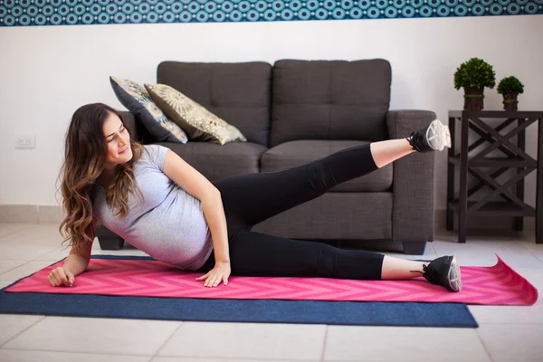 Mulher se exercitando em um tapete de ioga — Fotografia de Stock