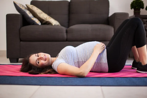 Morena deitado em um tapete de exercício — Fotografia de Stock