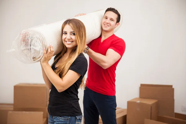 Couple carrying a rug — Stock Photo, Image