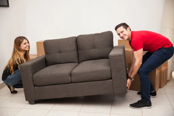 Newlyweds trying to move a couch — Stock Photo, Image