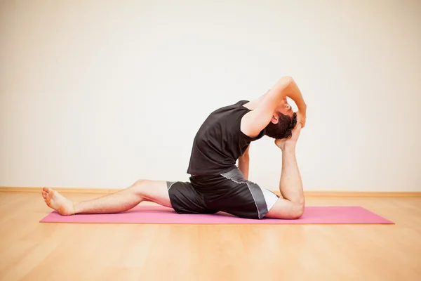 Hombre practicando unas cuantas poses de yoga — Foto de Stock