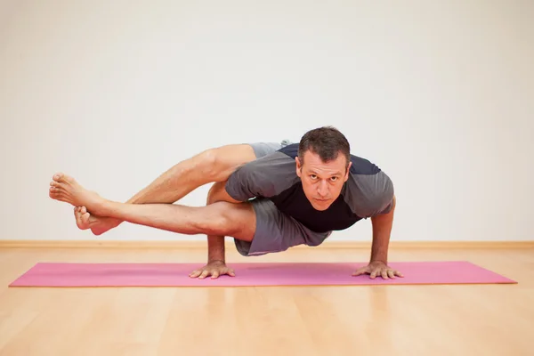 Hombre practicando unas cuantas poses de yoga — Foto de Stock