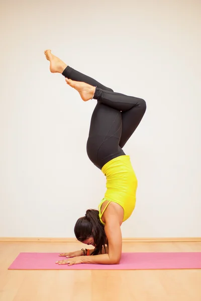 Brunetka robi headstand ze skrzyżowanymi nogami — Zdjęcie stockowe