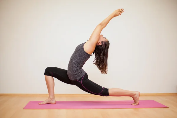 Brunett gör en låg utfall pose — Stockfoto