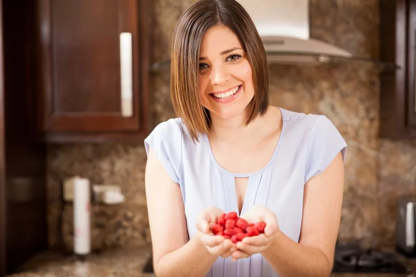 Mujer sosteniendo un montón de frambuesas — Foto de Stock