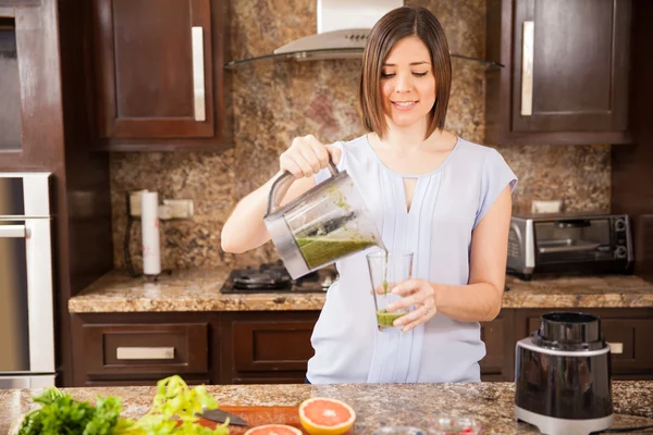 Mujer sirviendo jugo verde —  Fotos de Stock