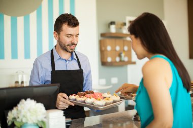 adam bir tepsi cupcakes gösterilen