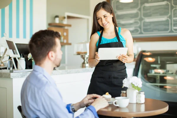 Empregada de mesa usando um computador tablet — Fotografia de Stock