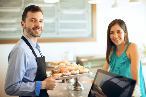 Uomo che mostra un vassoio di cupcake — Foto Stock