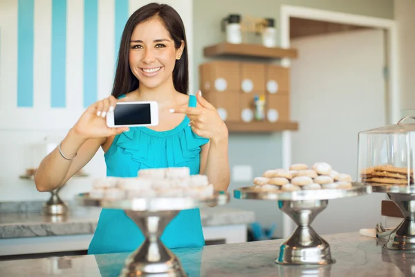 Frau zeigt auf ihr Smartphone — Stockfoto