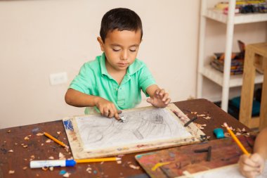 bir çizim üzerinde çalışan bir çocuk