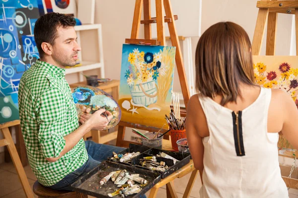 Man en vrouw vergelijken hun schilderijen — Stockfoto