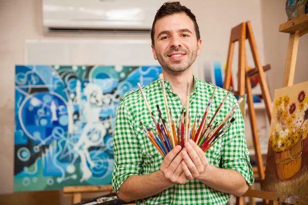 Artist holding a bunch of paintbrushes — Stock Photo, Image