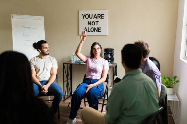 Grup terapisine katılan, deneyimleri paylaşan ve zihinsel sağlık, bağımlılık veya kedere destek bulan insanlar