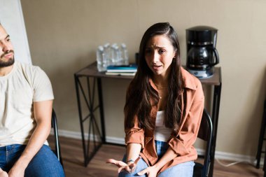 Duygusal sorunları paylaşan ve zihinsel sağlık terapisi sırasında grup üyelerinden destek alan kadın