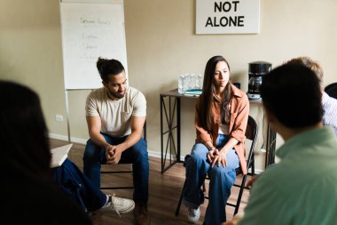 Grup terapi toplantısına katılan insanlar duygularını tartışıyor, zihinsel sağlık ve bağımlılık tedavisi için destek ve destek buluyor.