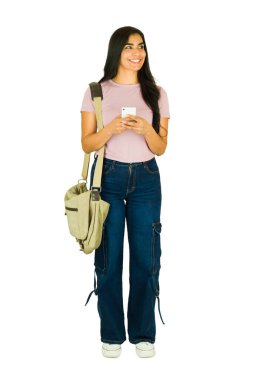 Çanta taşıyan ve elinde cep telefonu olan genç bir üniversite öğrencisi gülümserken mesaj atıyor.