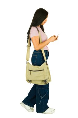 Kız öğrenci yürüyor, akıllı telefona bakıyor, mesajlaşıyor, günlük kıyafetler giyiyor ve kurye çantası takıyor.