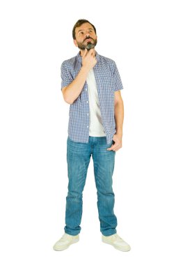 Düşünceli, sakallı, günlük kıyafetler giyen, uzun boylu, dik duran, yukarı bakıp düşünen, stüdyoda poz veren bir adam.