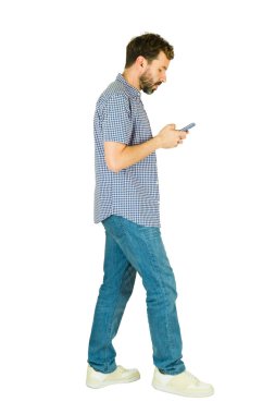 Uzun boylu adam yürüyor, cep telefonuna bakıyor, ekrandaki içeriği beyaz arkaplanla karşılaştırıyor