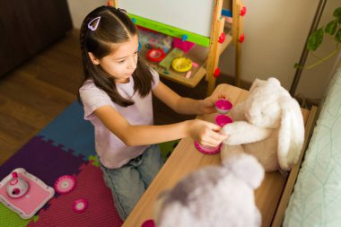 Pelüş bir oyuncak tavşana çay servisi yapan genç bir kız eğlenceli ve yaratıcı bir çocukluk anı yaratıyor.