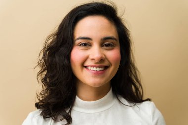 Yüzünde samimi bir gülümseme olan heyecanlı genç bir kadın beyaz kurdeleli balıkçı yaka ile poz veriyor. Mutlu ve neşeli bir duygu gösteriyor.