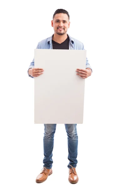 Hombre sosteniendo un signo blanco y sonriendo —  Fotos de Stock