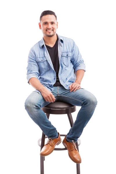 Man klädd vardagligen sitter på en stol — Stockfoto