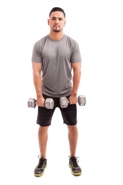Homem em roupas esportivas levantando halteres — Fotografia de Stock