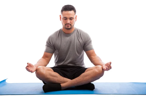 Man sitting on a yoga mat — Stock Photo, Image