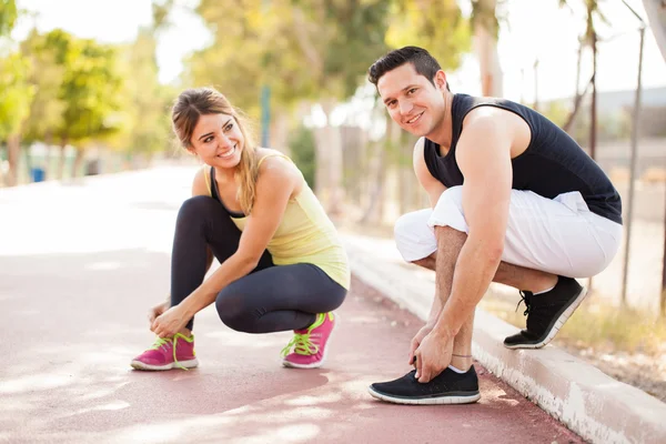 Couple tying their shoes — Stock Photo, Image