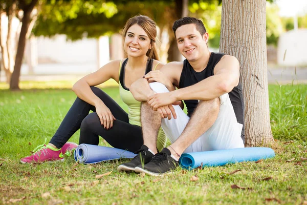 Paar mit Yogamatten sitzend — Stockfoto