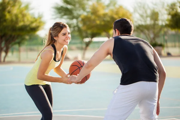 Женщина играет в баскетбол со своим парнем — стоковое фото