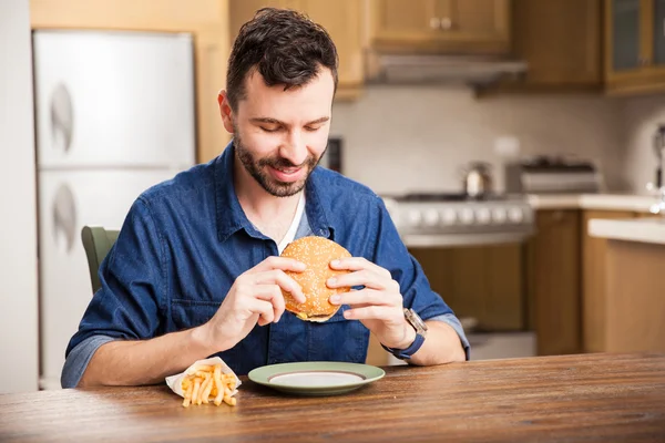 Uomo mangiare un hamburger — Foto Stock