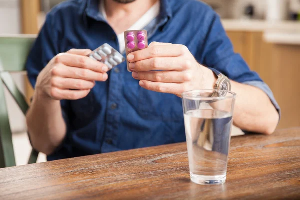 Hombre sosteniendo dos ampollas medicinales — Foto de Stock