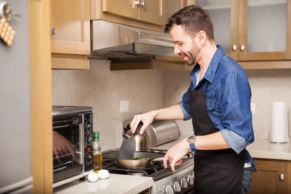 Uomo che indossa un grembiule e cucina — Foto Stock