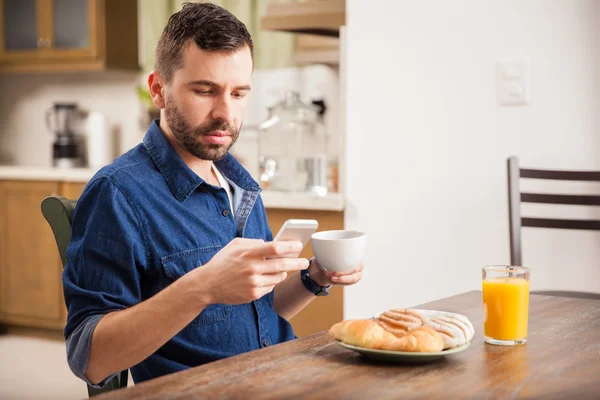 Cara com uma barba usando seu smartphone — Fotografia de Stock