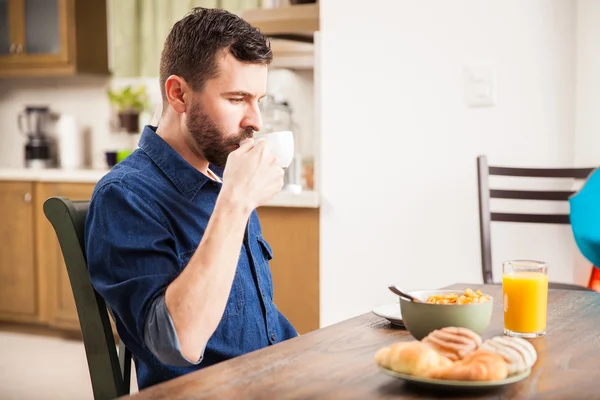 Hombre en una camisa de mezclilla bebiendo café —  Fotos de Stock