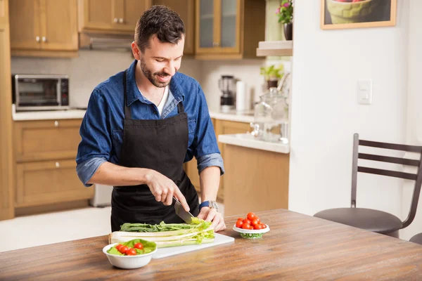 Uomo tagliare alcune verdure — Foto Stock