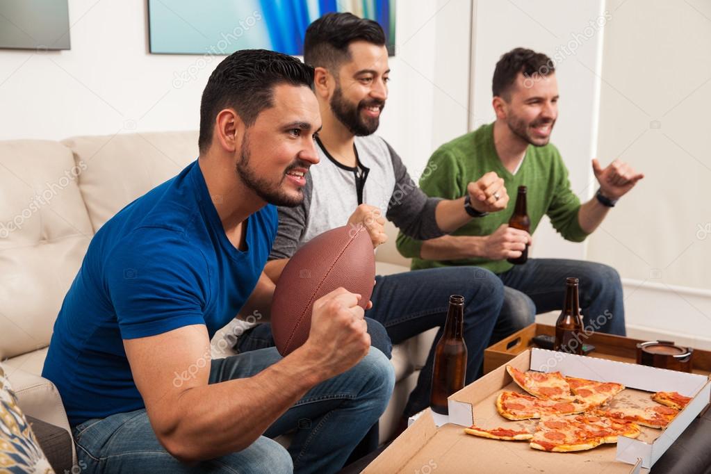 male friends cheering for their football team