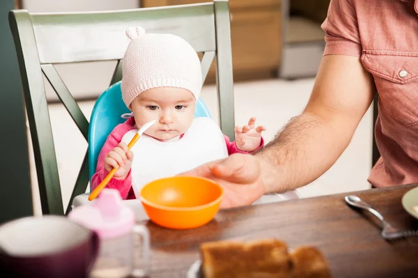 Baby girl trying to eat — Stock Photo, Image